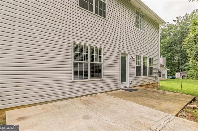 rear view of property featuring a yard and a patio area