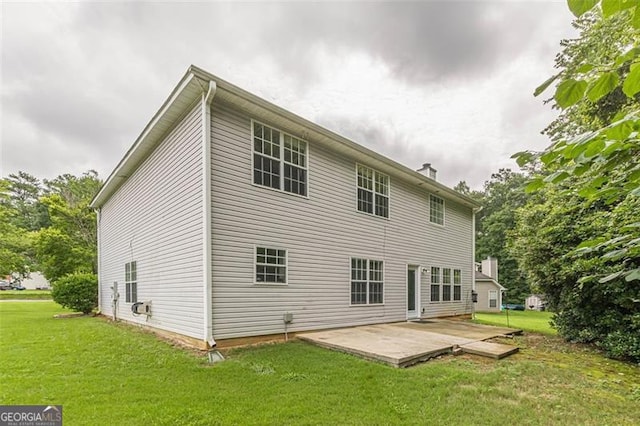 back of property with a lawn and a patio area