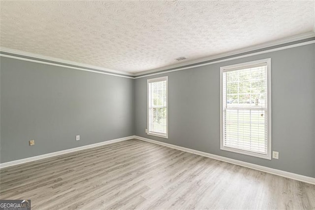 spare room with ornamental molding, light hardwood / wood-style floors, and a textured ceiling