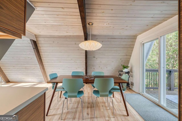 dining room featuring vaulted ceiling with beams, wooden walls, light hardwood / wood-style flooring, and wooden ceiling