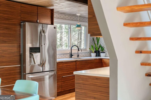 kitchen featuring pendant lighting, sink, wood ceiling, stainless steel fridge, and tasteful backsplash