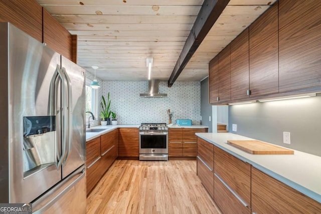 kitchen with sink, light hardwood / wood-style floors, stainless steel appliances, beam ceiling, and wall chimney exhaust hood