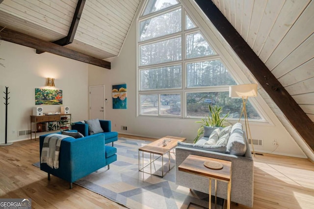 living room with a healthy amount of sunlight, high vaulted ceiling, light hardwood / wood-style floors, and beamed ceiling