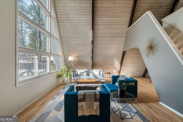 living room featuring beamed ceiling, wood-type flooring, and high vaulted ceiling