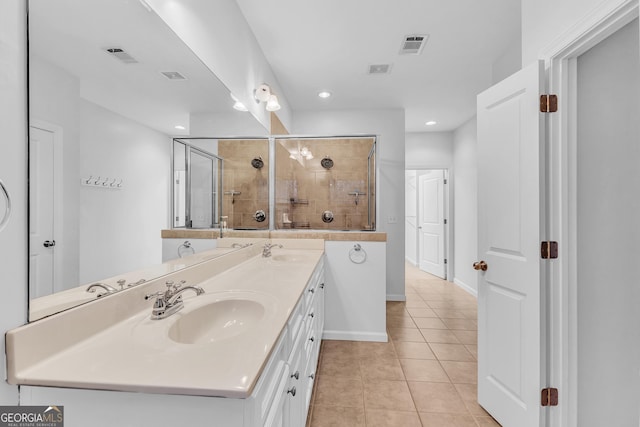 bathroom with an enclosed shower, vanity, and tile patterned floors