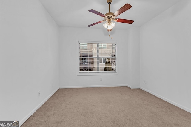 spare room featuring light colored carpet and ceiling fan