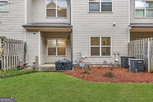 rear view of property featuring a yard and a patio area