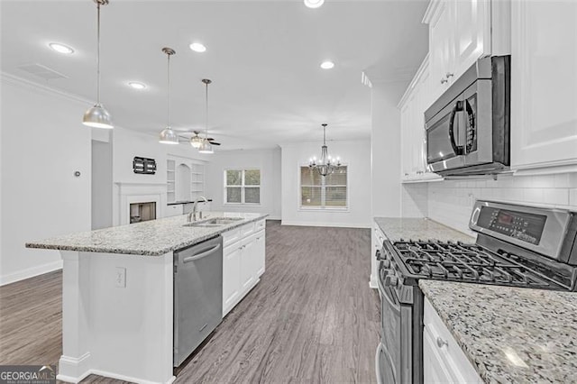 kitchen with stainless steel appliances, a center island with sink, and white cabinets