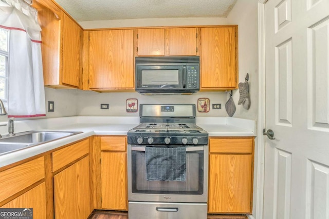 kitchen with sink, stainless steel range with gas cooktop, and a textured ceiling