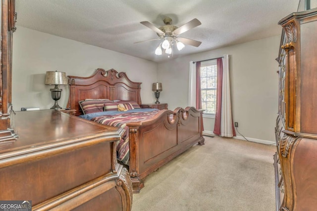 bedroom with ceiling fan, light colored carpet, and a textured ceiling