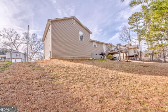 view of side of property featuring a yard and a deck