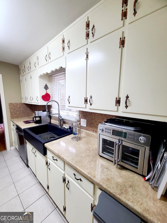 kitchen featuring white cabinets, backsplash, sink, and dishwasher