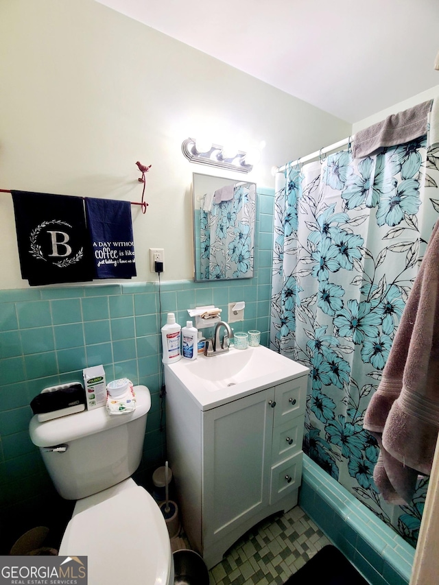 bathroom featuring vanity, tile walls, toilet, and walk in shower