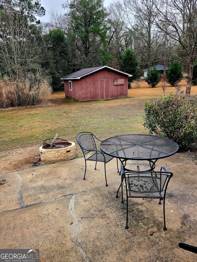 view of patio / terrace featuring a storage shed and a fire pit