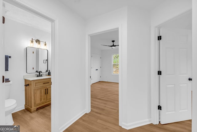 bathroom featuring vanity, ceiling fan, wood-type flooring, and toilet