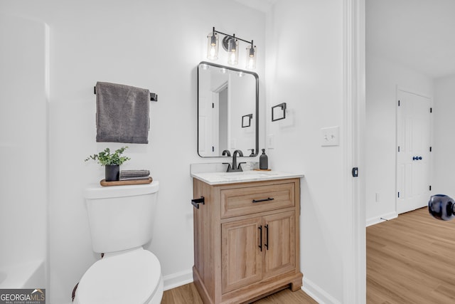 bathroom with vanity, hardwood / wood-style floors, and toilet