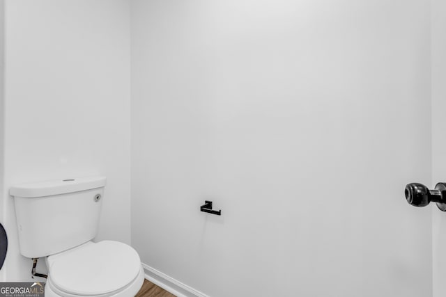 bathroom featuring wood-type flooring and toilet