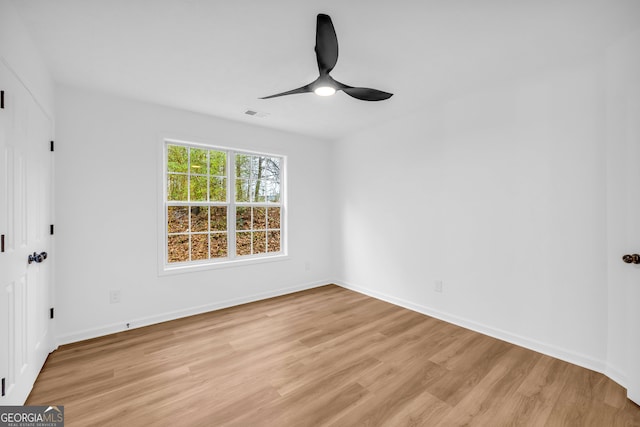 spare room with ceiling fan and light wood-type flooring