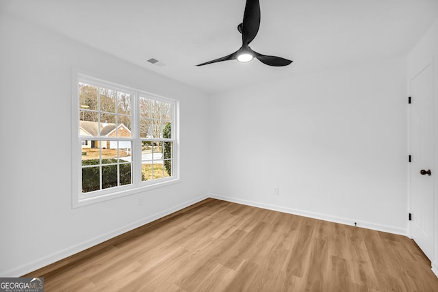 empty room with ceiling fan, a healthy amount of sunlight, and light wood-type flooring