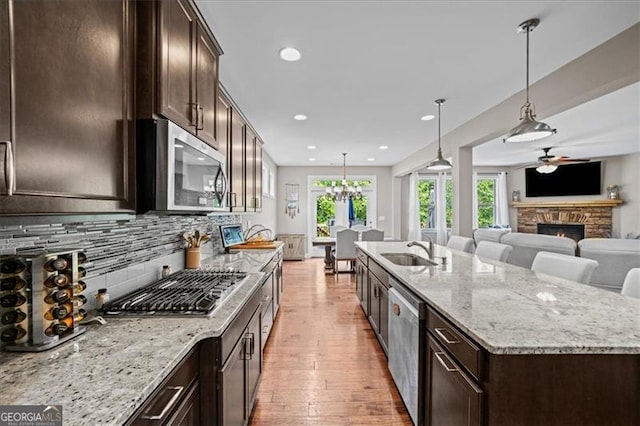 kitchen with a spacious island, stainless steel appliances, sink, and hanging light fixtures