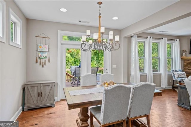 dining space with hardwood / wood-style floors and a notable chandelier