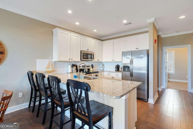 kitchen featuring appliances with stainless steel finishes, kitchen peninsula, and white cabinets