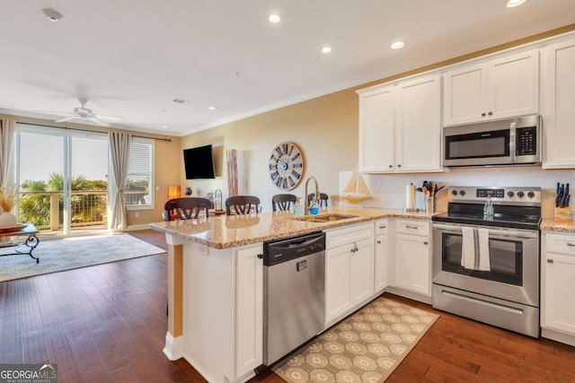 kitchen featuring stainless steel appliances, white cabinetry, sink, and kitchen peninsula