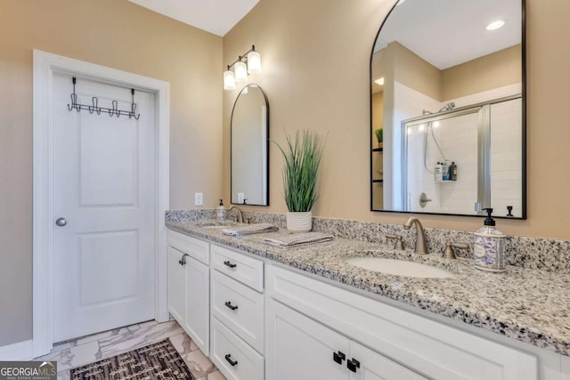 bathroom with a shower with door and vanity