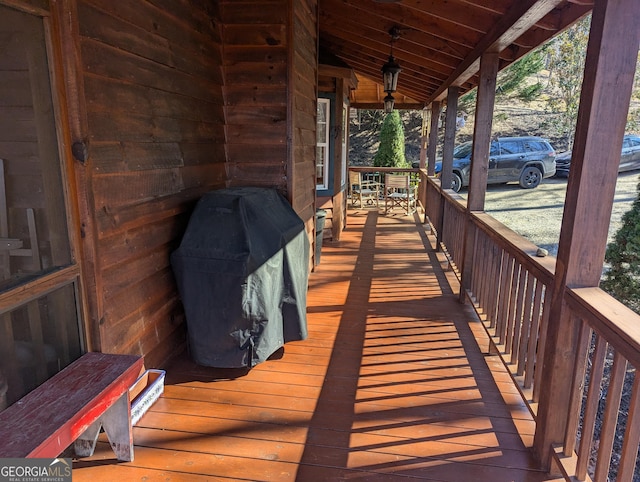 wooden terrace featuring a grill and a porch