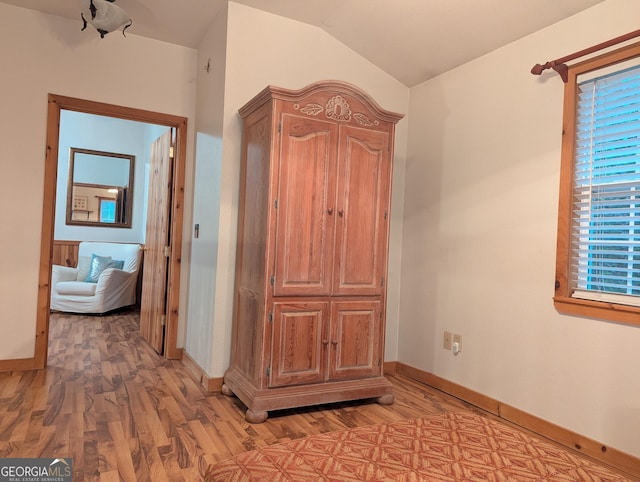 hallway featuring lofted ceiling and light wood-type flooring