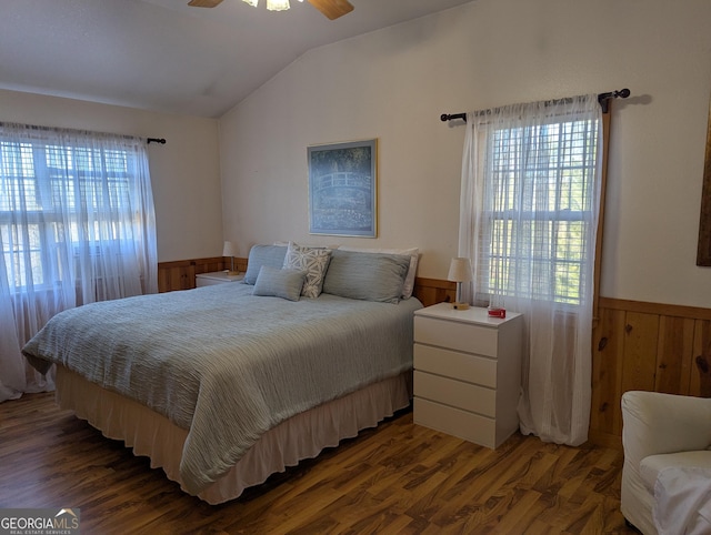 bedroom featuring lofted ceiling, dark hardwood / wood-style floors, and wood walls