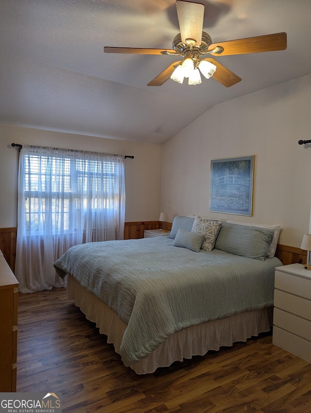 bedroom featuring dark hardwood / wood-style flooring, vaulted ceiling, and ceiling fan