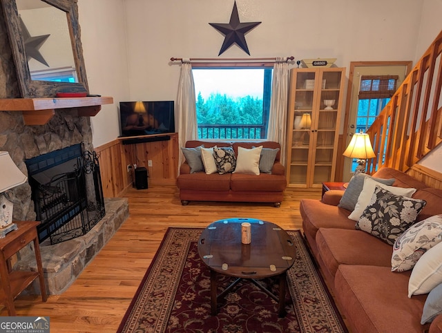 living room with a stone fireplace and hardwood / wood-style floors