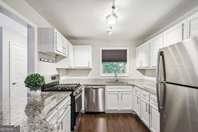 kitchen with dark hardwood / wood-style floors, sink, white cabinets, light stone counters, and stainless steel appliances