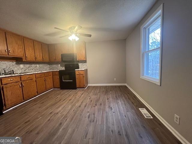 kitchen featuring sink, decorative backsplash, hardwood / wood-style flooring, electric range, and ceiling fan