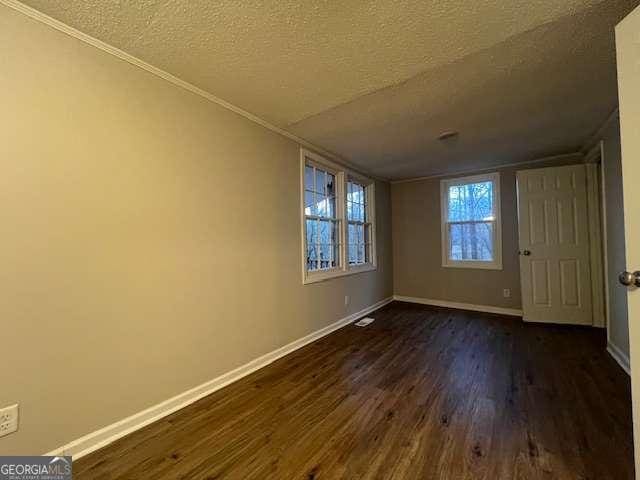 spare room featuring dark hardwood / wood-style floors and a textured ceiling