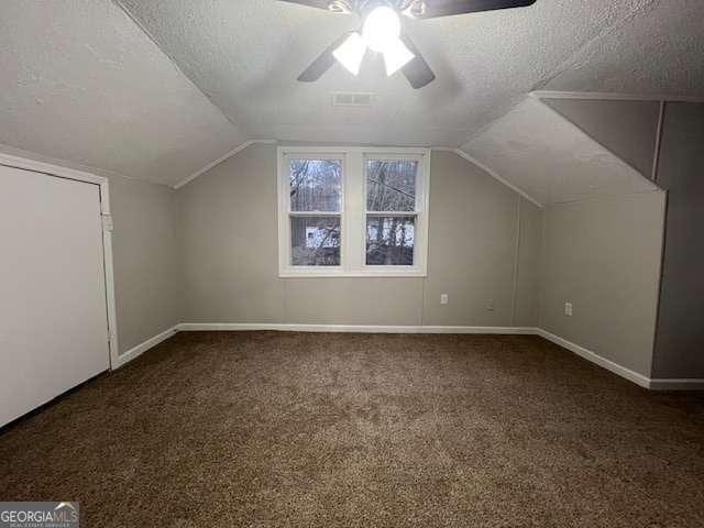 bonus room featuring lofted ceiling, a textured ceiling, and carpet flooring