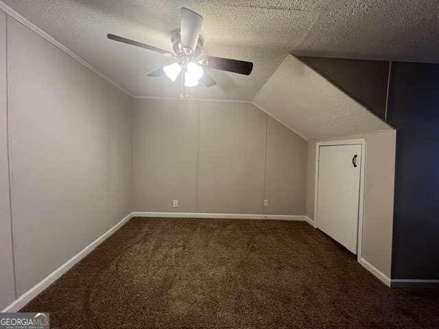 bonus room with vaulted ceiling, ceiling fan, a textured ceiling, and dark carpet