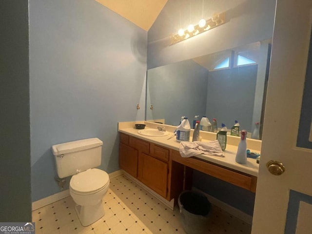 bathroom with lofted ceiling, vanity, and toilet