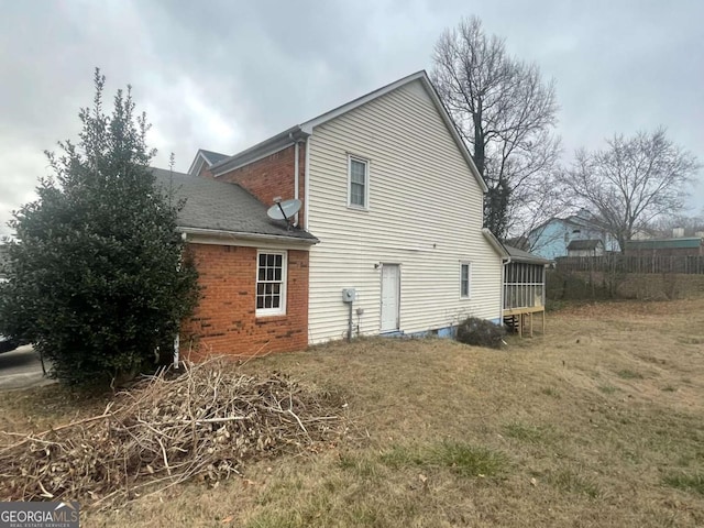 back of house featuring a yard and a sunroom