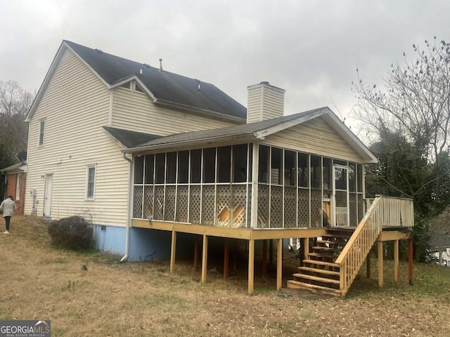 back of house featuring a wooden deck and a sunroom