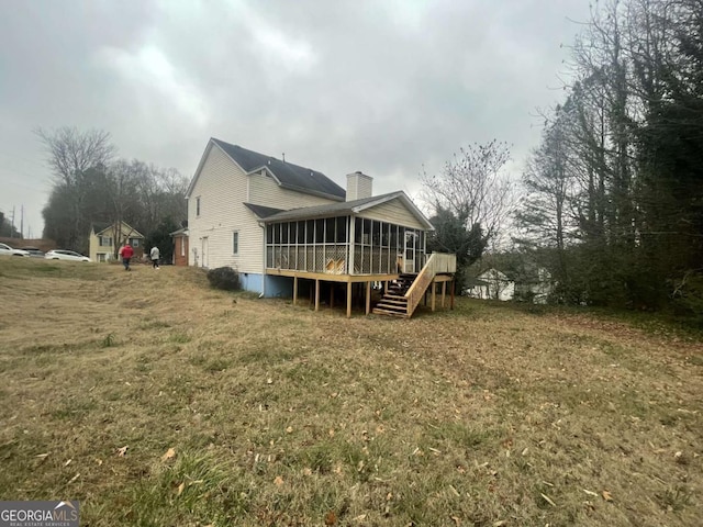 back of house featuring a sunroom, a yard, and a deck