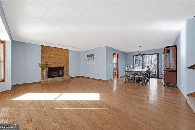 unfurnished living room featuring hardwood / wood-style floors, a fireplace, and a textured ceiling