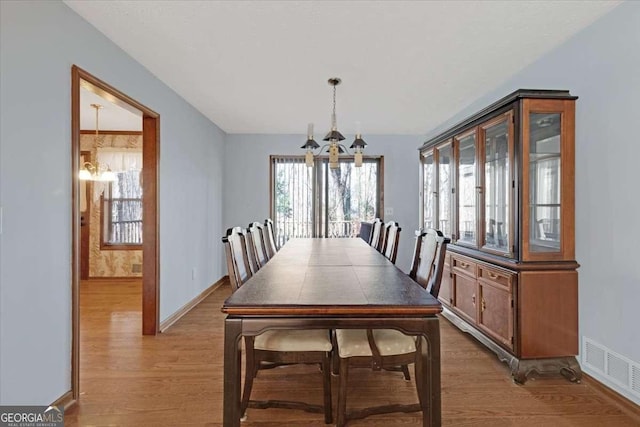 dining space with an inviting chandelier and hardwood / wood-style flooring