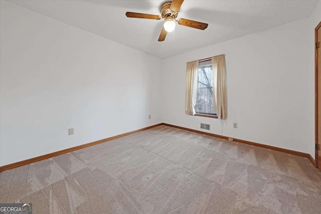 spare room with ceiling fan and carpet