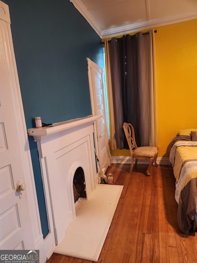 bedroom with crown molding and hardwood / wood-style floors