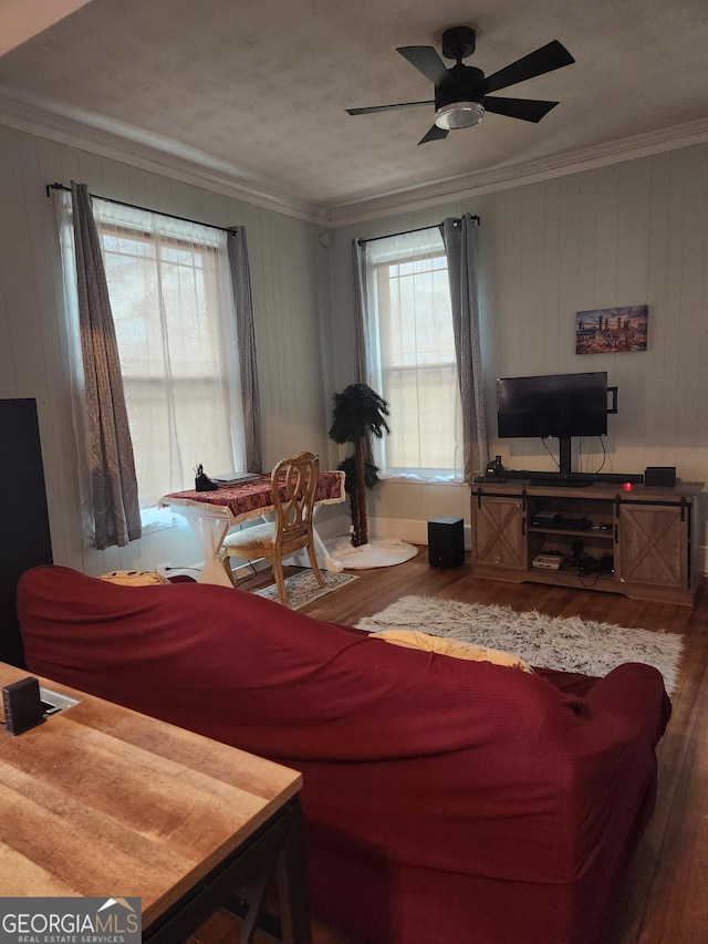 living room featuring crown molding, wood-type flooring, and ceiling fan