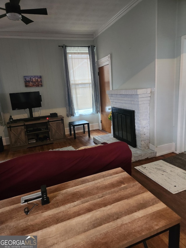 bedroom with ornamental molding, a brick fireplace, and wood-type flooring