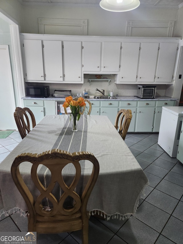 tiled dining room featuring sink