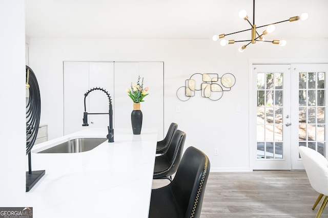 kitchen featuring french doors, wood-type flooring, sink, and white cabinets